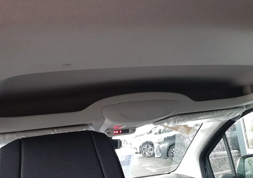 Vue intérieure avant droite du Citroën Berlingo 2026, montrant le plafond clair et le siège avant en tissu gris noir.