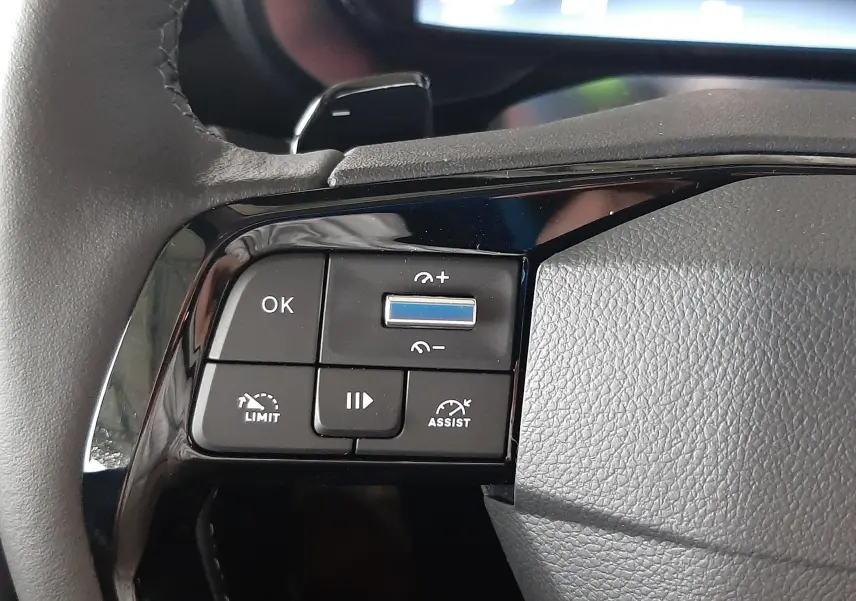 Gros plan sur les commandes au volant noir du Citroën Berlingo 2026, avec boutons de régulateur et assistant de conduite.