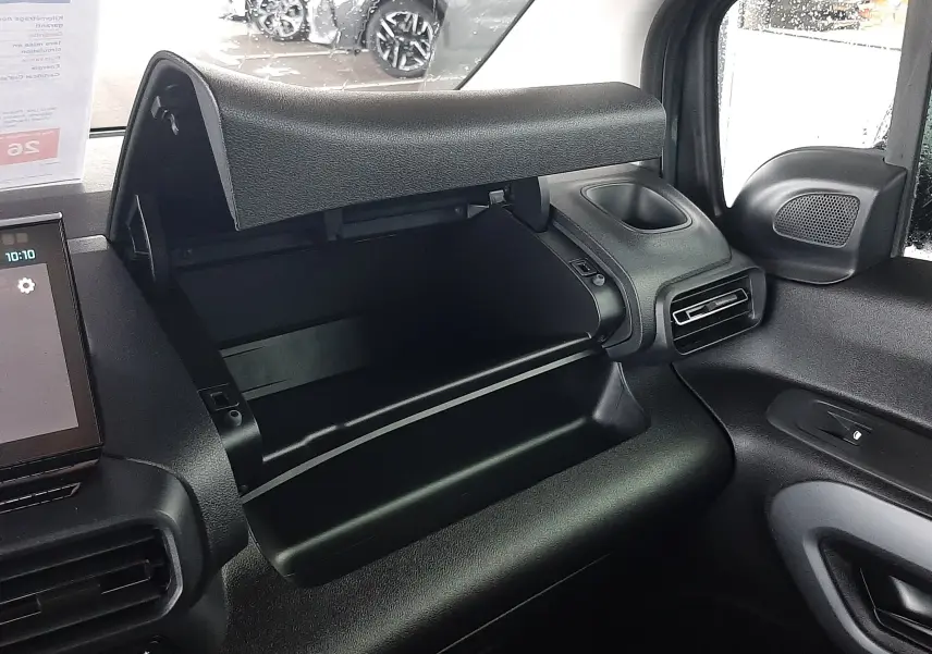 Vue intérieure côté passager du Citroën Berlingo 2026 bleu Kiama, avec boîte à gants ouverte et tableau de bord noir.