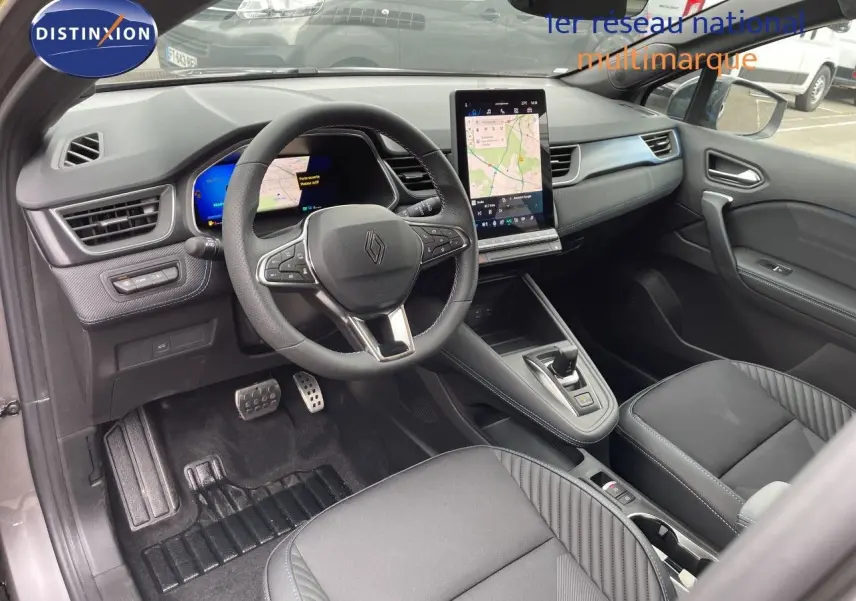 Intérieur avant droit de la Renault SYMBIOZ gris cassiopée, volant multifonction et écran tactile vertical visible.