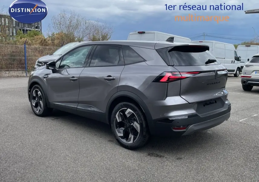 Renault Symbioz gris cassiopée métal en 3/4 arrière droit, avec feux arrière LED et jantes modernes bicolores.
