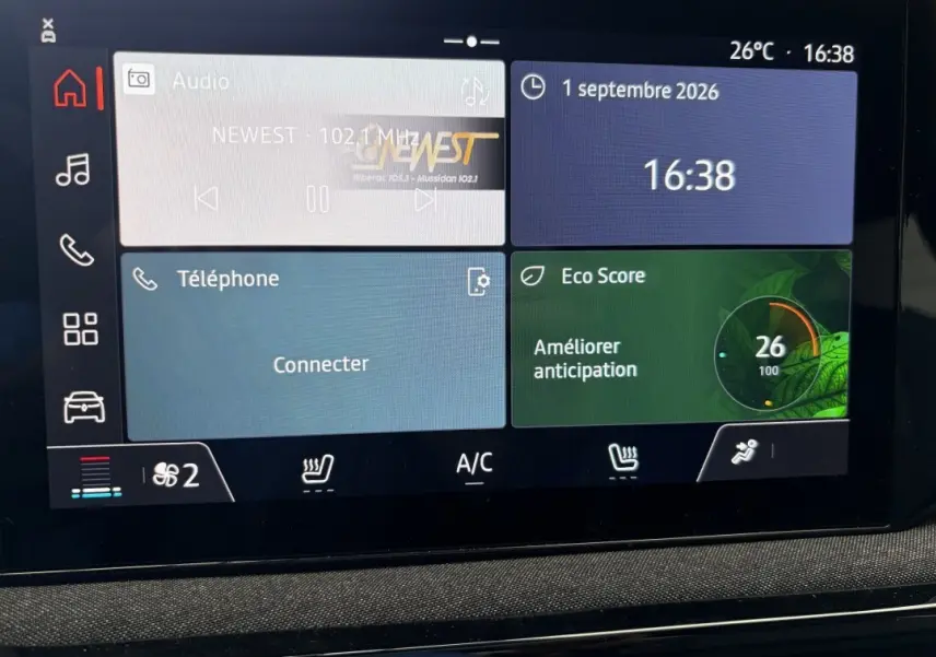 Écran tactile central de la Renault Clio Evolution+ hybride rouge 2025 affichant radio, téléphone et Eco Score.