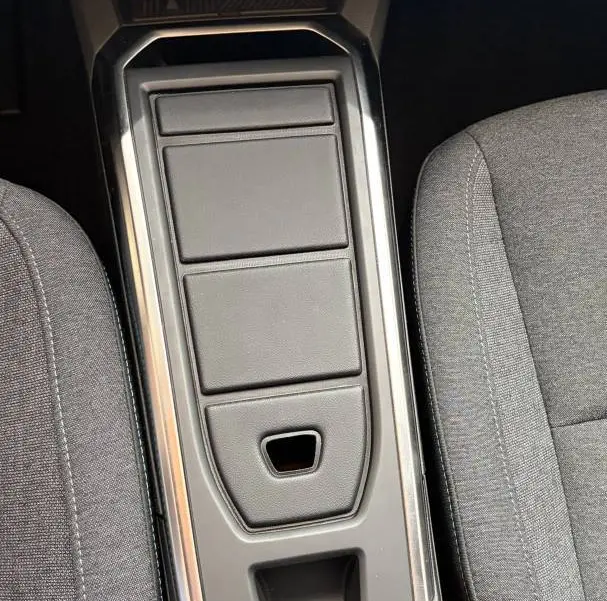 Vue plongeante sur la console centrale noire de la Renault Clio Evolution hybride 2025 avec commandes électroniques et sièges gris.