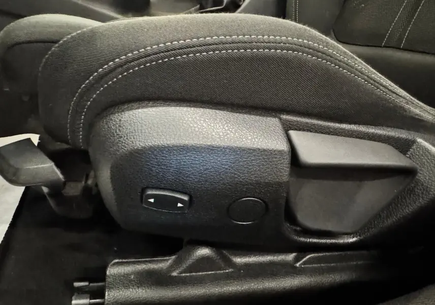 Gros plan sur les commandes latérales du siège avant en tissu noir de la BMW Série 3 Touring F31 gris aluminium.
