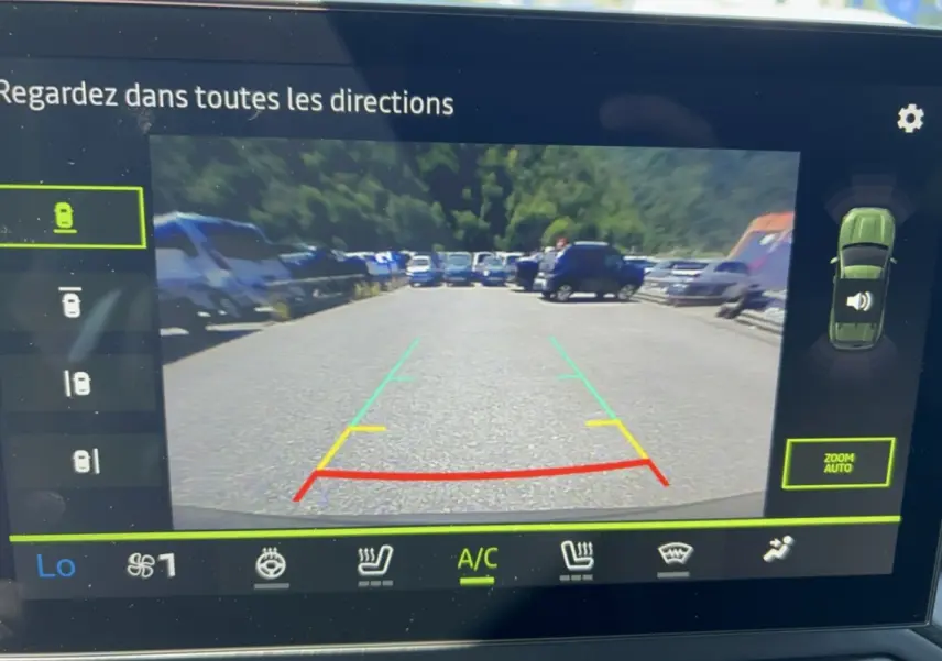 Vue écran caméra multiview du Dacia Duster vert cèdre 2026, affichant la zone arrière avec lignes de guidage colorées.