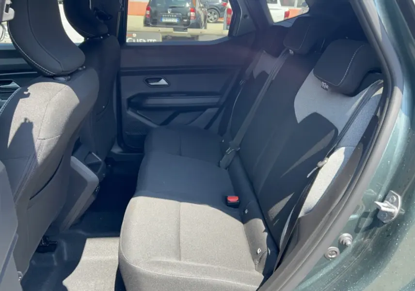 Vue intérieure côté droit montrant la banquette arrière noire du Dacia Duster Hybrid-G 150 4x4 en vert cèdre.