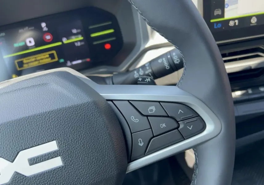 Gros plan sur le volant cuir à commandes multifonctions côté droit du Dacia Duster Hybrid-G 150 4x4 2026.