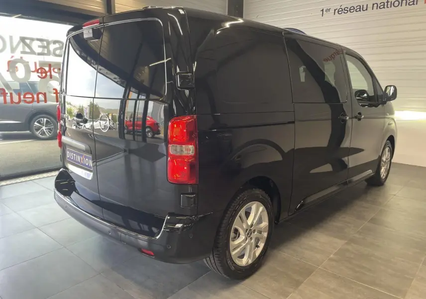 Vue 3/4 arrière droite d'un Opel Vivaro noir carbone avec portes arrière battantes et jantes argentées.