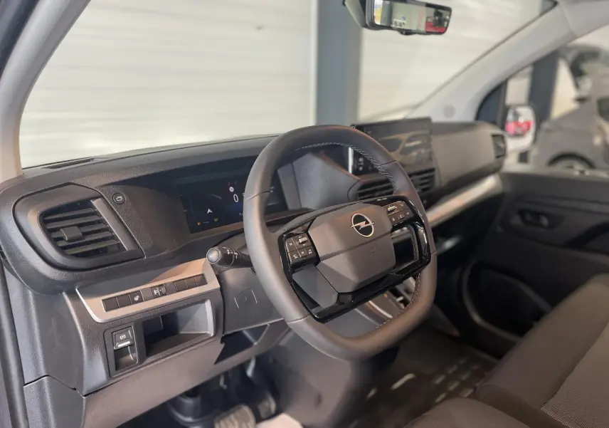 Intérieur de l'Opel Vivaro 2025 côté conducteur, volant multifonction et tableau de bord moderne noir.