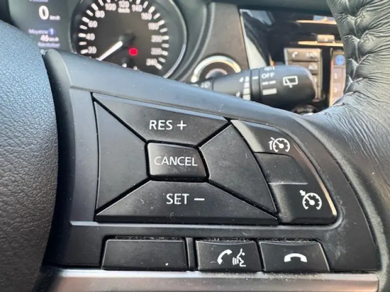 Gros plan sur les commandes de régulateur de vitesse et téléphone au volant cuir du Nissan X-TRAIL noir intense 2018.