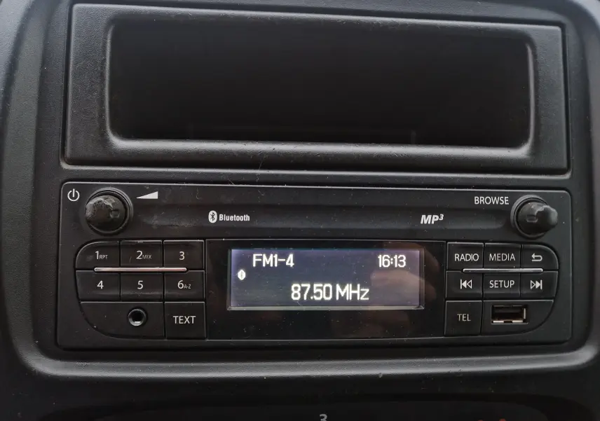 Gros plan sur la radio MP3 intégrée du Renault Trafic Fourgon blanc, affichant la fréquence FM 87.50 MHz.