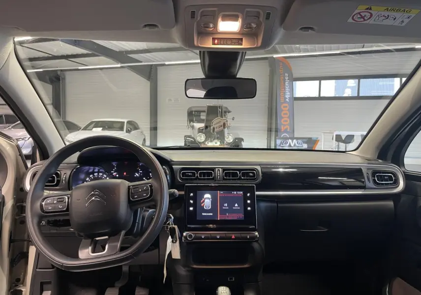 Intérieur avant de la Citroën C3 beige clair 2024, tableau de bord avec écran tactile et volant multifonction.