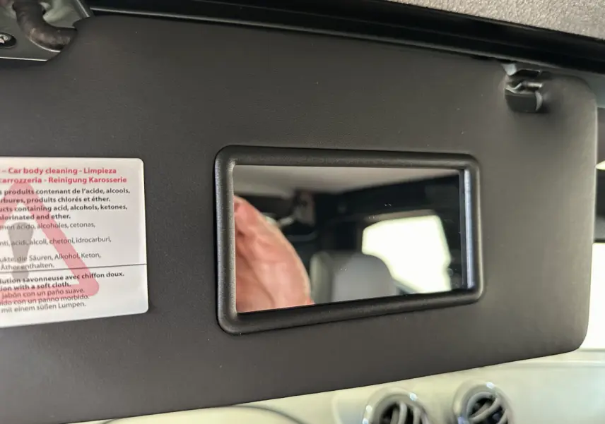 Miroir de courtoisie intégré au pare-soleil côté conducteur de l'AIXAM AMBITION 0.5 CITY PACK bleu, vue intérieure rapprochée.