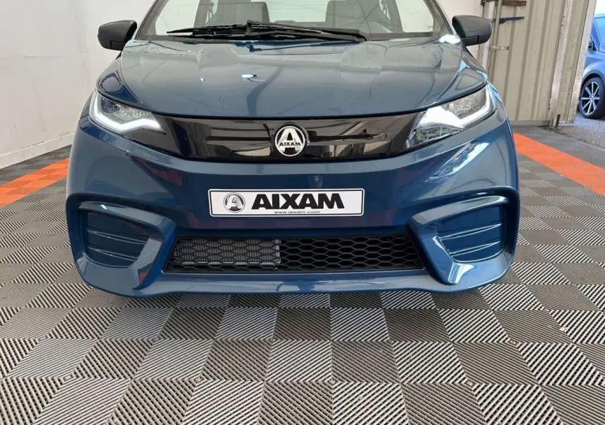 Vue frontale d'une Aixam Ambition 0.5 City Pack bleu 2026 avec calandre noire brillante et phares LED marqués.