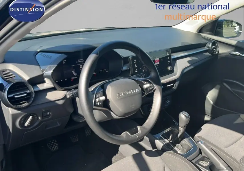 Vue intérieure côté conducteur de la Skoda Fabia 2025 noire, montrant le volant multifonction et la console avec boîte manuelle.