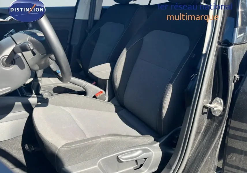 Vue intérieure côté conducteur de la Skoda Fabia 2025 noir magique métal, montrant les sièges en tissu gris foncé et la boîte manuelle.