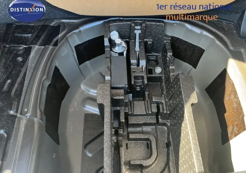 Coffre ouvert montrant le rangement pour roue de secours d'une Skoda Fabia noire, avec compartiments en mousse noire.