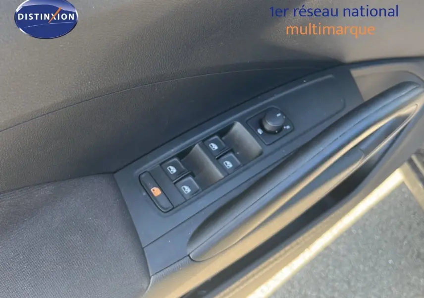 Détail de la commande des vitres électriques sur la porte côté conducteur d'une Skoda Fabia noire.