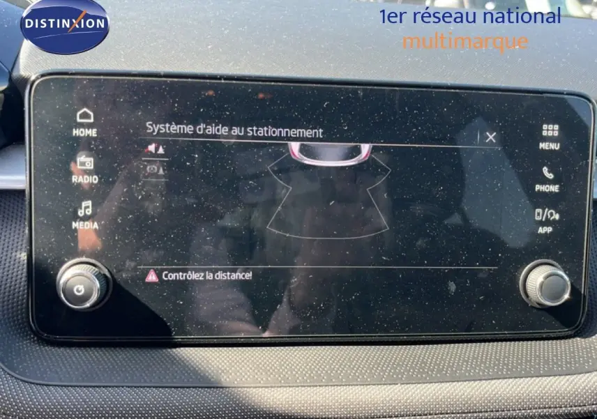 Écran tactile du système d'aide au stationnement de la Skoda Fabia 2025, avec commandes autour et reflet visible.