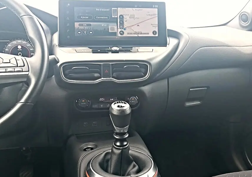 Intérieur du Nissan Juke 2025, vue centrale sur la console avec levier de vitesse manuel et écran tactile couleur.