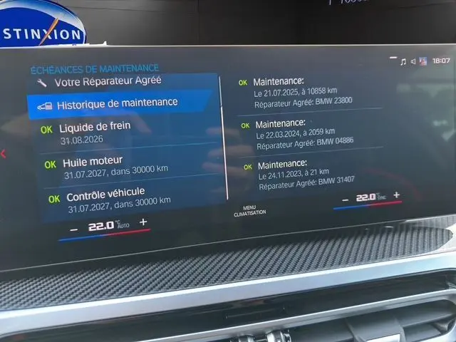 Écran numérique du tableau de bord de la BMW M2 G87 affichant l'historique de maintenance et la climatisation à 22°C.