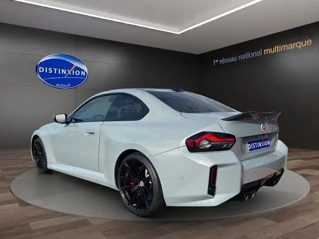 BMW M2 G87 gris Brooklyn Grau vue 3/4 arrière droit, jantes noires et aileron sportif visible