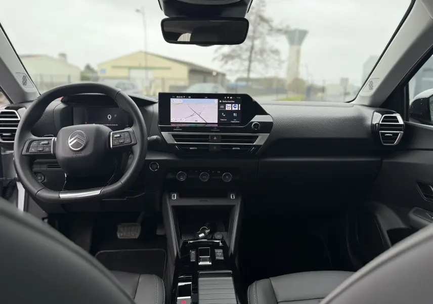Vue intérieure frontale du tableau de bord et volant noir du Citroën C4 Hybrid 145 e-DCS6 Max 2025.