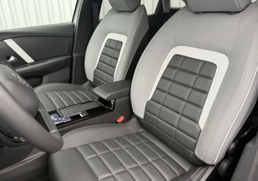 Intérieur de la Citroën C4 Hybrid 145 e-DCS6 Max 2025, vue sur les sièges avant en cuir gris et blanc Okenite.