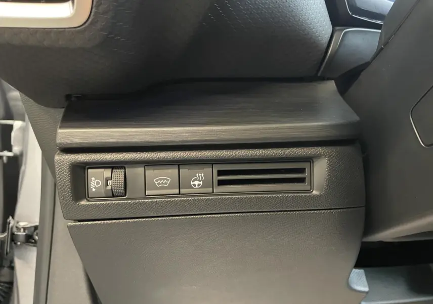 Détail intérieur du tableau de bord côté gauche de la Citroën C5 X 2024 gris foncé avec commandes et sortie d’air.