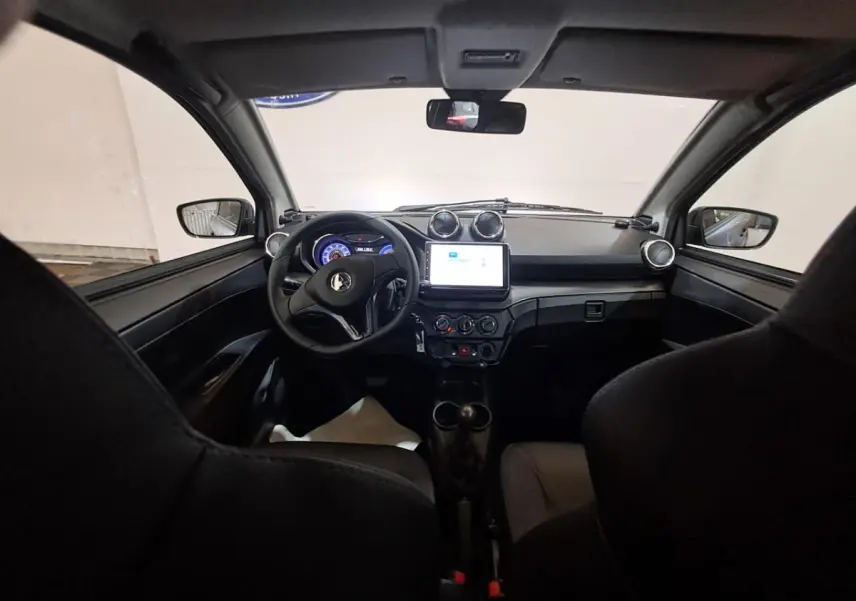 Vue intérieure avant de l'Aixam Ambition 2024, tableau de bord noir avec écran tactile et volant compact.