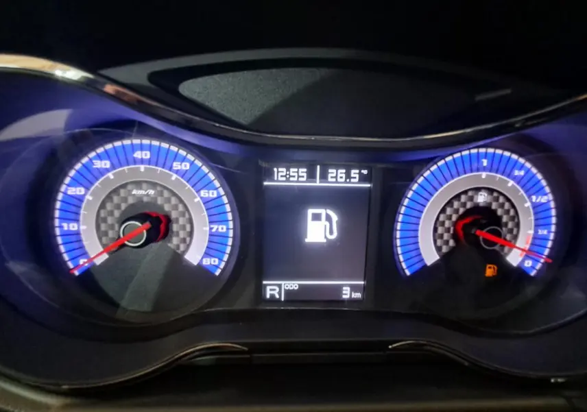 Tableau de bord éclairé en bleu de l'Aixam Ambition 2024, affichant vitesse, jauge carburant et écran central numérique.