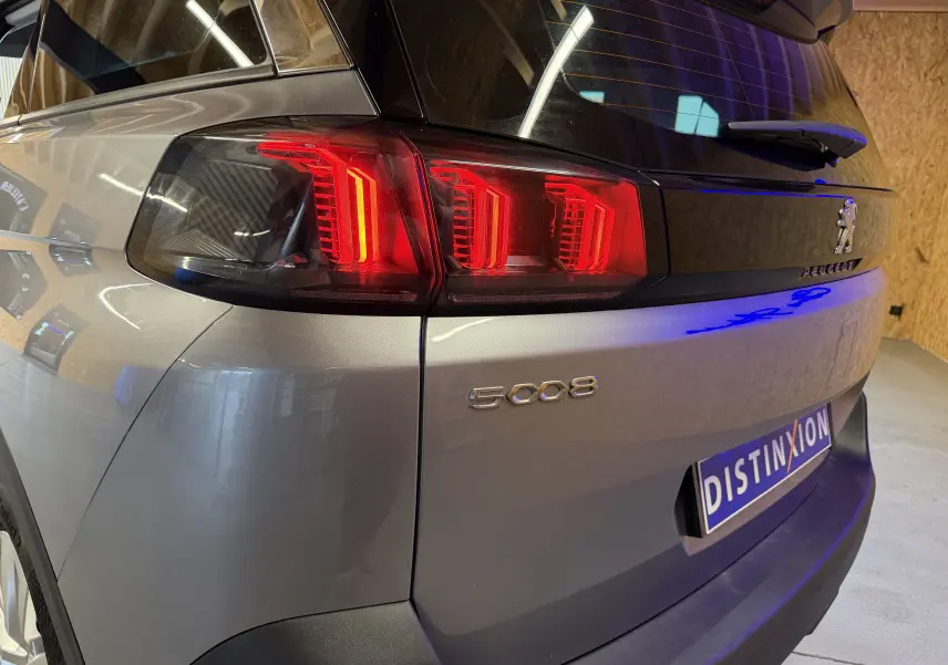 Vue arrière droite du Peugeot 5008 gris 2021, mettant en valeur les feux arrière à LED et le logo distinctif.