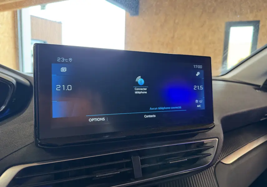 Écran tactile central du tableau de bord du Peugeot 5008 gris, affichant la connectivité Bluetooth et la climatisation.