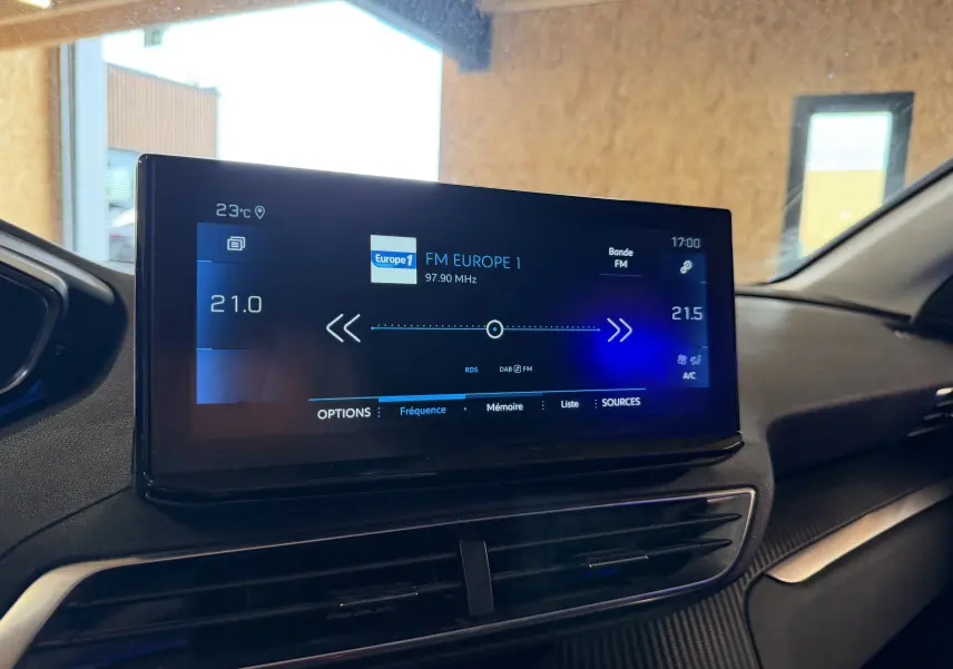 Écran tactile central du tableau de bord du Peugeot 5008 1.5 BlueHDi 130, affichant la radio FM Europe 1.