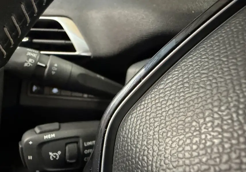Gros plan sur le volant en cuir noir et les commandes de régulateur de vitesse du Peugeot 5008 1.5 BlueHDi 130 Allure.
