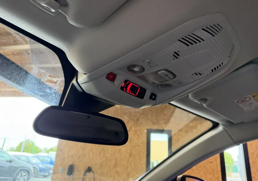 Vue intérieure du plafond avant du Peugeot 5008 gris, avec commandes d’éclairage et rétroviseur central visible.