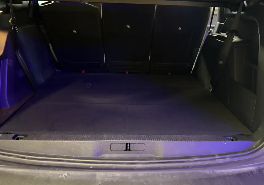 Coffre ouvert en vue arrière d'un Peugeot 5008 gris 1.5 BlueHDi 130 Allure avec banquette arrière rabattue et intérieur noir.