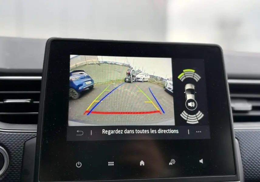 Écran tactile intérieur montrant la caméra de recul avec vue arrière et aides au stationnement du Renault Arkana bleu Zanzibar.