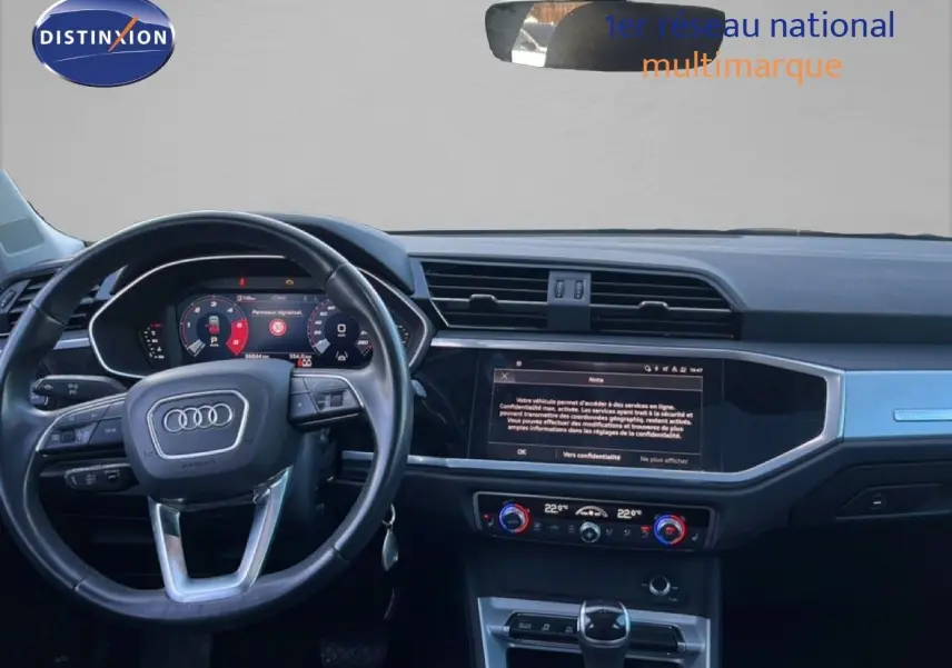 Vue intérieure du tableau de bord et volant noir d'un Audi Q3 Sportback 35 TDI 2022 avec écran tactile et commandes climatisation.