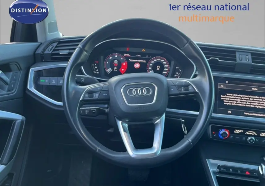 Vue intérieure centrée sur le volant noir et le tableau de bord digital de l'Audi Q3 Sportback 35 TDI 2022.