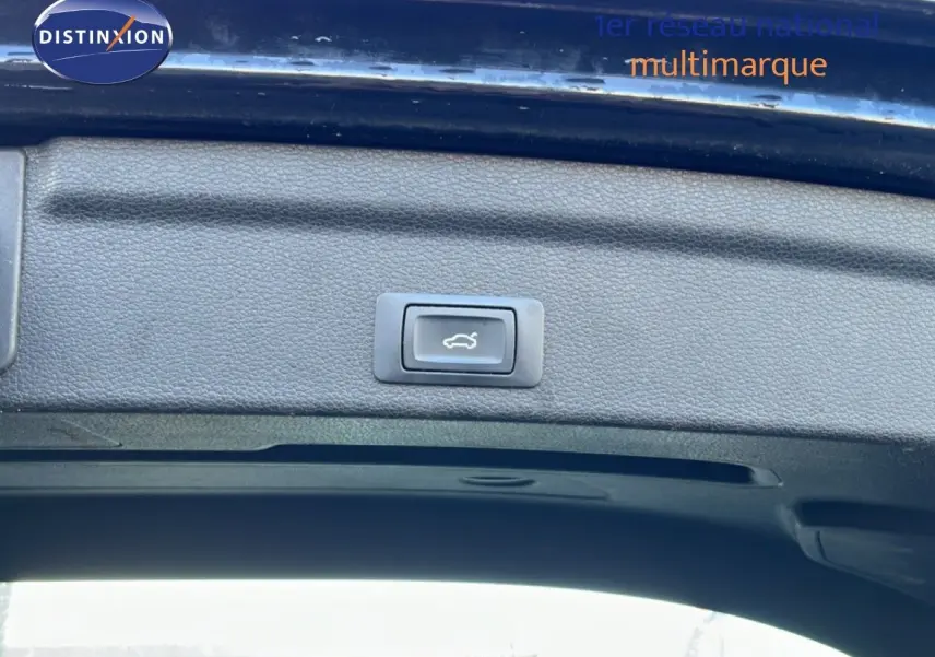 Bouton d'ouverture électrique du coffre sur la partie intérieure du hayon d'un Audi Q3 Sportback noir, vue en contre-plongée.