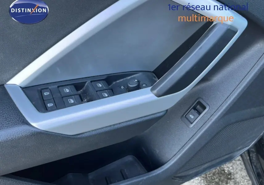 Gros plan sur la commande des vitres et le bouton de déverrouillage sur la porte côté conducteur d’un Audi Q3 Sportback noir.