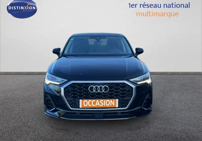 Vue frontale d'un Audi Q3 Sportback 35 TDI 150 S-Line noir avec calandre hexagonale et phares LED allumés.