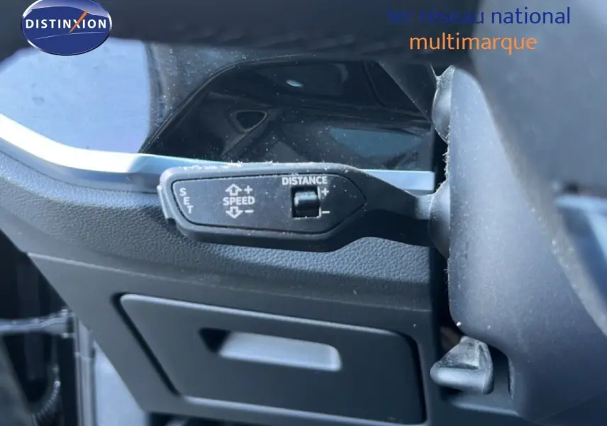 Gros plan sur la commande de régulateur de vitesse au volant d’un Audi Q3 Sportback noir, vue intérieure côté conducteur.