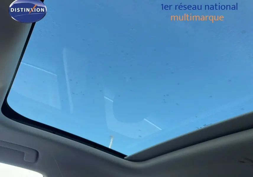Toit panoramique en verre vu de l'intérieur de l'Audi Q3 Sportback noir, laissant entrevoir un ciel bleu.
