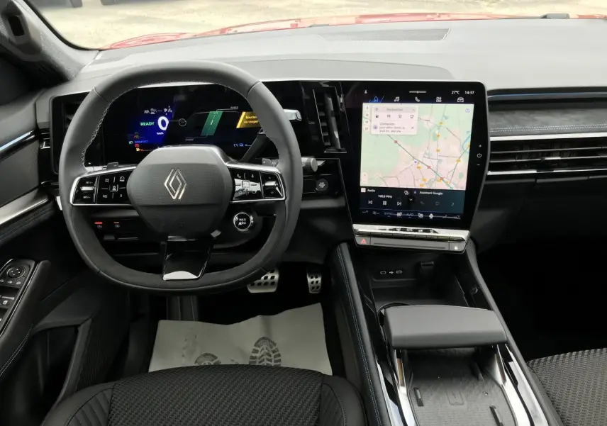Vue intérieure frontale du tableau de bord et volant noir du Renault Austral full hybrid avec écran tactile vertical.