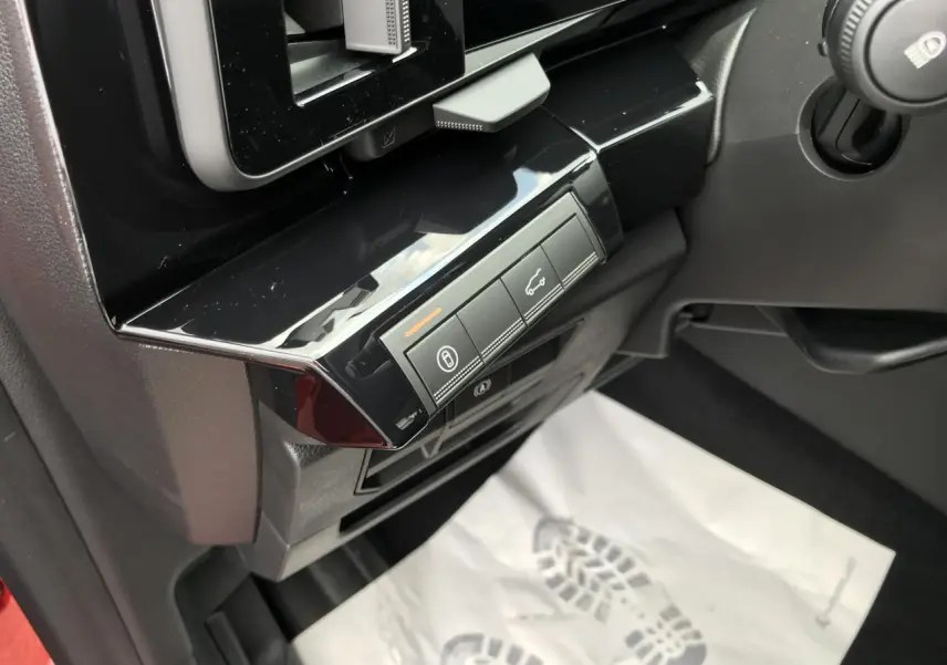 Gros plan sur les commandes noires brillantes côté gauche du tableau de bord du Renault Austral rouge et noir.