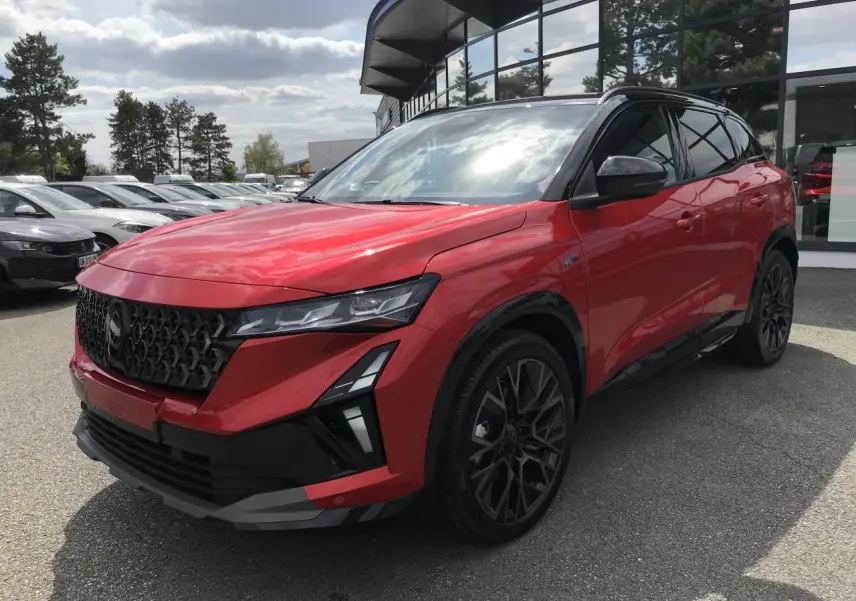 Renault Austral 2025 rouge et noir en 3/4 avant, avec jantes noires et calandre au design distinctif.