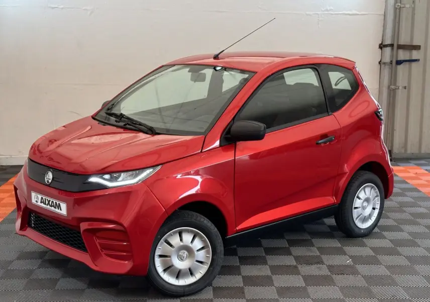 Vue 3/4 avant d'une Aixam Ambition E City Pack rouge 2026 avec rétroviseur caméra côté conducteur.
