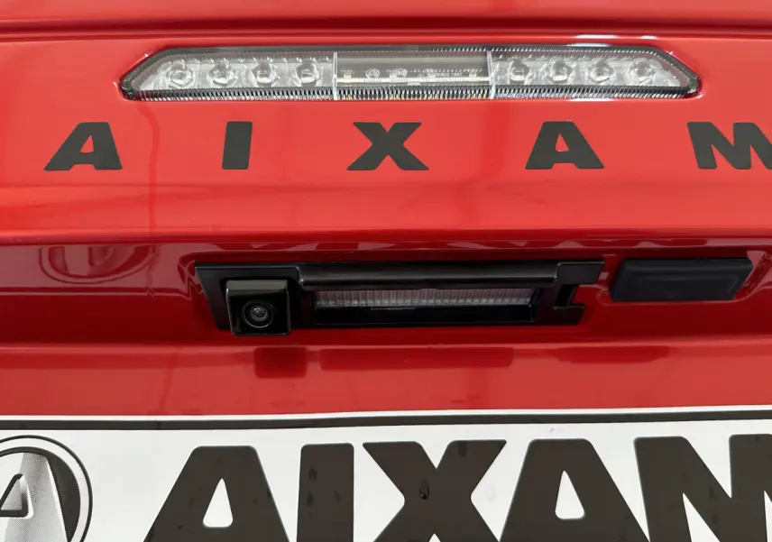 Gros plan sur la caméra de recul et le feu stop arrière du coffre rouge de l'AIXAM AMBITION E CITY PACK 2026.